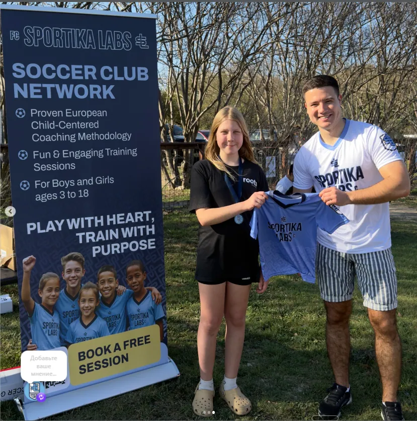 A young player with Tagir at the Austin community fair, holding a Sportika Labs jersey