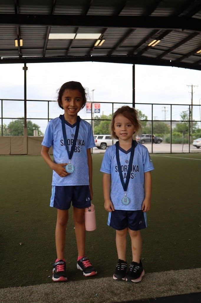 Two young players holding their Sportika Labs medals after a trial session