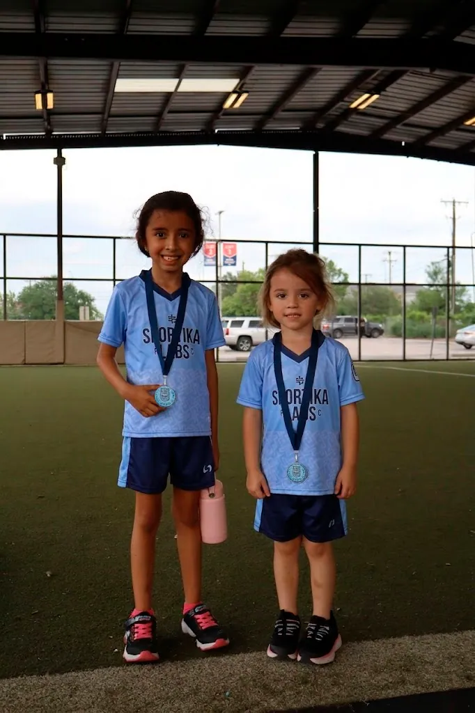 Two young players holding their Sportika Labs medals after a trial session